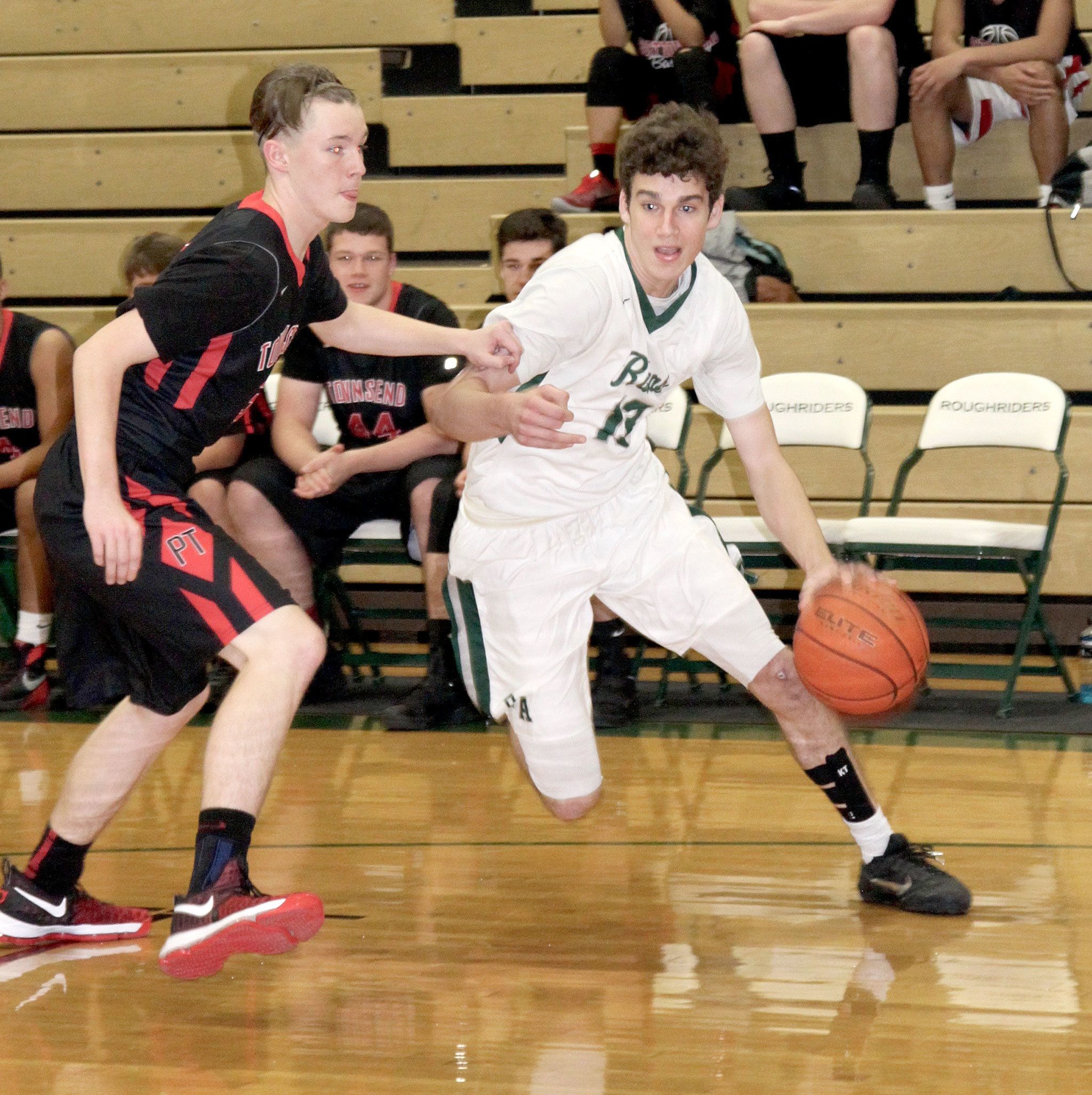 Dave Logan/For the Peninsula Daily News                                Port Angeles&rsquo;s Luke Angevine, right, drives around Seth Spencer of Port Townsend at the Port Angeles Jamboree Monday night. The Roughriders hosted Port Townsend and Forks at the jamboree.