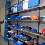 Keith Thorpe/Peninsula Daily News Lefties baseball owner Matt Acker looks over a shelf of team t-shirts and caps at the franchise&rsquo;s storefront at 117 W. First St., in downtown Port Angeles on Tuesday.