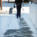 Sonny Carter of Port Angeles carries a snow shovel as he prepares to clear the sidewalk in the 1100 block of South Cherry Street in Port Angeles on Tuesday morning. (Keith Thorpe/Peninsula Daily News)