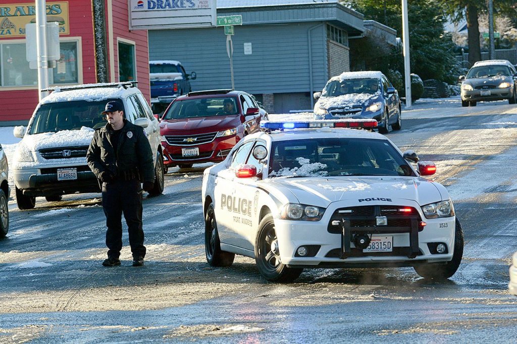A Port Angeles police officer blocks Lincoln Street on Tuesday morning. Police blocked streets as cars slid and got stuck. (Jesse Major/Peninsula Daily News)