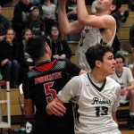 Keith Thorpe/Peninsula Daily News Port Angeles&rsquo; Grayson Peet, top, looks for the hoop as teammate Luke Angevine, front left, fends off the defense of Blaine;s Anthony Ball in the fourth quarter on Saturday at Port Angeles High School.