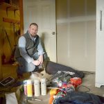 East Jefferson Little League Director Kenny Yingling stands by a pile of baseball gear, kitchen supplies and tools piled on the floor after a break-in to the Little League building in Port Hadlock on Dec. 5 and 10. (Cydney McFarland/Peninsula Daily News)