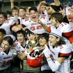 The Associated Press Neah Bay players celebrate with the trophy after they beat Odessa-Harrington 64-34 in the Class 1B state championship.