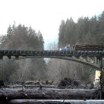 A logging truck makes its way across the U.S. 101 bridge over the Elwha River last week. (Keith Thorpe/Peninsula Daily News)