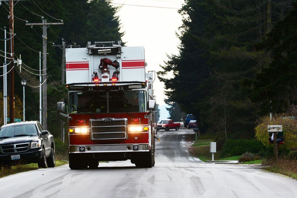 Firefighters arrive at a house on the west end of Port Angeles that caught fire Sunday morning. (Jesse Major/Peninsula Daily News)