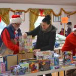 Sheena Touchard of Sequim looks for toys for her four children ages 6-13 with help from volunteers Joel Ogden and Anne Notman at Toys for Sequim Kids on Dec. 14. Organizers said 400 children in Sequim received items from the event. (Matthew Nash/Olympic Peninsula News Group)