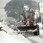 A road grader-turned-snow plow leads a procession of cars down a snow-covered section of Eighth Street in Port Angeles on Dec. 29, 1996. (Keith Thorpe/Peninsula Daily News)