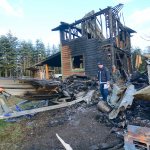 Firefighters searched Monday for the cause of a fire that destroyed a Carlsborg home on New Year&rsquo;s Day. (Jesse Major/Peninsula Daily News)