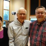 Stan Peterson stands flanked by long-time friends Carol and Larry Simmons at Peterson&rsquo;s retirement party Saturday at the Forks Rainforest Arts Center. (Zorina Barker/for Peninsula Daily News)