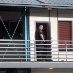 Port Angeles police Officer Mike Johnson stands watch at an office suite at Eighth and Vine streets where the suspect in a fatal shooting was arrested on Thursday. (Keith Thorpe/Peninsula Daily News)