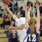 Keith Thorpe/Peninsula Daily News Port Angeles&rsquo; Nizhoni Wheeler, left, squeezes between the defense of North Kitsap&rsquo;s Ashley Vest, front right, and Raelee Moore for a layup attempt in the first quarter of play on Tuesday at Port Angeles High School.