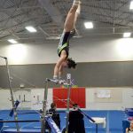 Port Angeles gymnast Maya Wharton flips her way to a first-place finish on the bars and in the all-around during an away meet against North Kitsap on Wednesday.