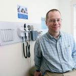 Dr. Jeff Weller of Peninsula Children&rsquo;s Clinic sits in one of the exam rooms in the clinic&rsquo;s new building. (Jesse Major/Peninsula Daily News)