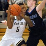 Keith Thorpe/Peninsula Daily News Peninsula&rsquo;s Darrion Daniels, left, approaches the lane as Edmond&rsquo;s K.J. Hassett defends in the first half on Saturday evening in Port Angeles.