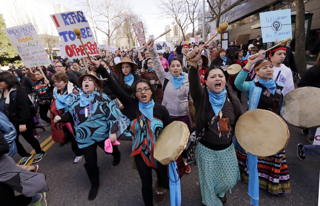 Native American singers and drummers lead a women&rsquo;s march of thousands as it arrives at the Seattle Center on Saturday in Seattle. (Elaine Thompson/The Associated Press)