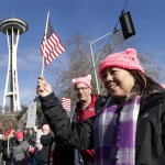 Marchers numbering in the thousands arrive at the Seattle Center and in view of the Space Needle on Saturday in Seattle. (Elaine Thompson/The Associated Press)