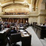 Rep. Pat Sullivan, D-Covington, left, speaks on the state House floor on Monday at the Capitol in Olympia. (Ted S. Warren/The Associated Press)
