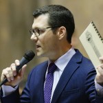 Senate Republican floor leader Joe Fain, R-Auburn, holds up a guide to protocol on the Senate floor as he speaks Friday in Olympia. (Ted S. Warren/The Associated Press)