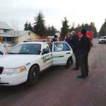Cole Hall, second from left, is photographed after his arrest by Clallam County Sheriff&rsquo;s Deputy Mark Millet, second from right. Deputy Andrew Wagner, Medic Joel Bower and Deputy Chris Moon, from left, look on. (Clallam County Sheriff&rsquo;s Office)