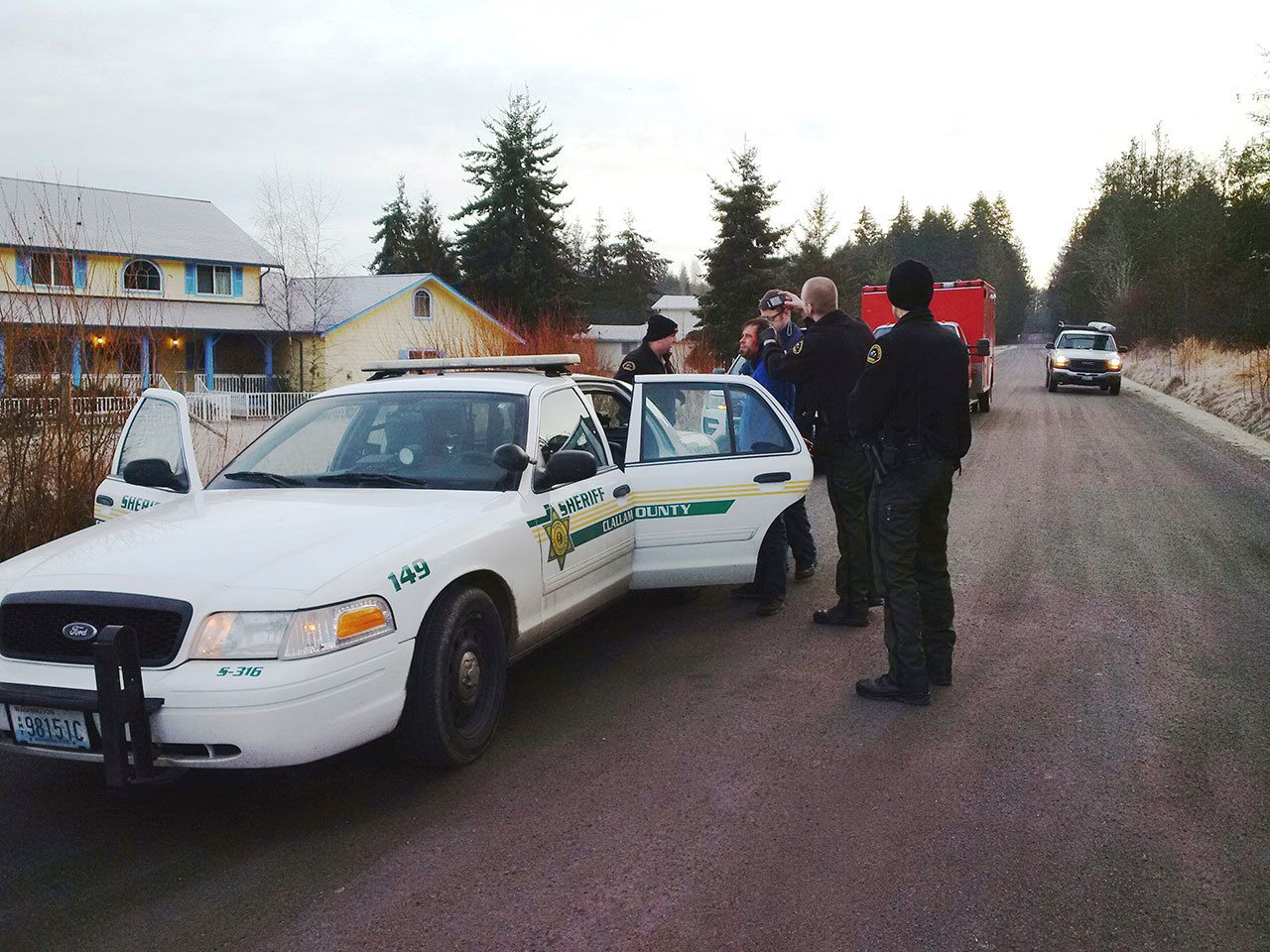 Cole Hall, second from left, is photographed after his arrest by Clallam County Sheriff&rsquo;s Deputy Mark Millet, second from right. Deputy Andrew Wagner, Medic Joel Bower and Deputy Chris Moon, from left, look on. (Clallam County Sheriff&rsquo;s Office)