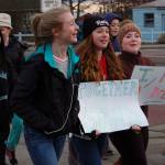Eighth-graders Olivia Preston, right, and Mary Mcaller, center, hold signs alongside Maya Reiter during the Sequim Middle School Martin Luther King Day Jr. walk.