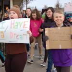 Eighth-grader Olivia Preston, left, shows a sign that reads &ldquo;I Have a Dream&rdquo; while seventh-grader Jack Van de Wege, right, holds a sign that says &ldquo;Injustice Anywhere is a threat to Justice Everywhere.&rdquo; (Erin Hawkins/Olympic Peninsula News Group)