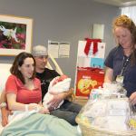 Monica Rice, Jason Rutherford and their newborn son, Jason Michael Rutherford Jr., were presented Sunday with the OMC Auxiliary&rsquo;s first annual first-baby-of-the-year gift basket. They are seen here with Registered Nurse Lynette Brown. (Dave Logan/for Peninsula Daily News)