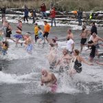 Participants in the 29th annual polar bear plunge in downtown Port Angeles rush into the water at Hollywood Beach on Sunday morning. (Dave Logan/for Peninsula Daily News)