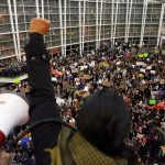Seattle city councilwoman and socialist activist Kshama Sawant raises a fist over the crowd Saturday as more than 1,000 people gather at Seattle-Tacoma International Airport to protest President Donald Trump&rsquo;s order that restricts immigration to the U.S. (Genna Martin/seattlepi.com via AP)
