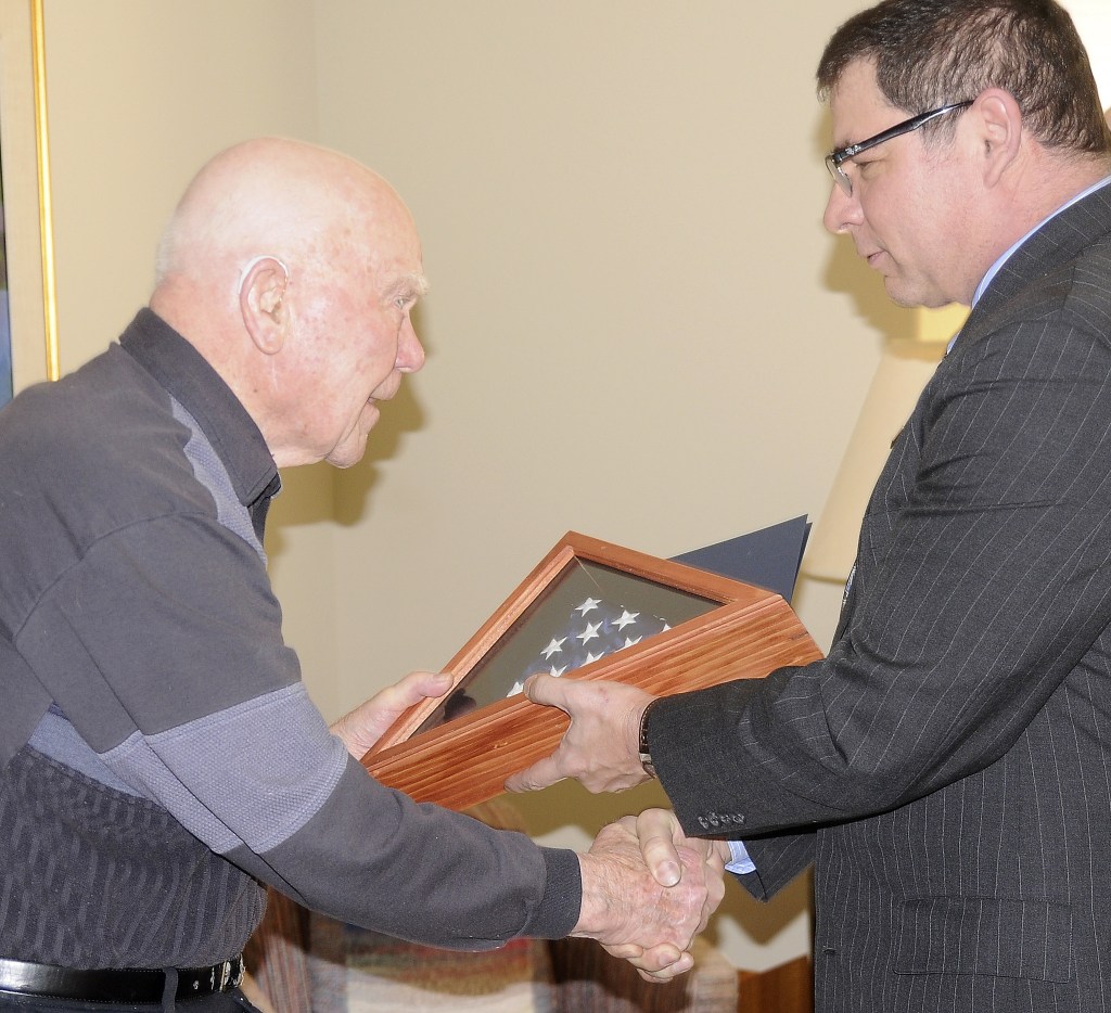 Michael Dashiell/Olympic Peninsula News Group                                Pearl Harbor veteran Roy Carter accepts an American flag from Tim Katona, president of the Navy League Bremerton-Olympic Peninsula Council.