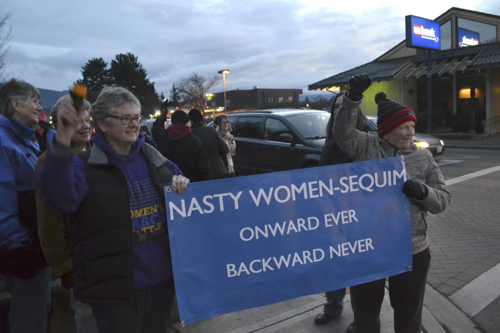Kathi White and Donna Maclean hold one of the few signs up at the women&rsquo;s rights rally in downtown Sequim last Saturday. Maclean said their sign is a response to President Donald Trump calling his opponent Hillary Clinton a &ldquo;nasty woman&rdquo; at a debate. (Matthew Nash/Olympic Peninsula News Group)