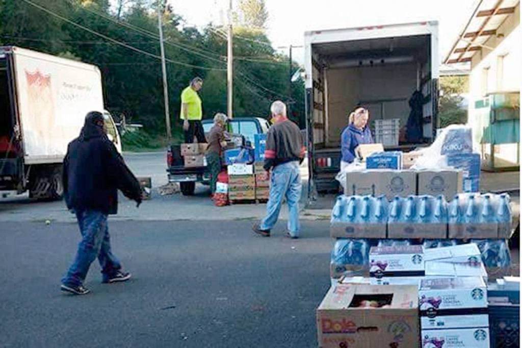 Officials with the Forks Food Bank, Sequim Food Bank, Salvation Army, Port Angeles Food Bank and Serenity House load supplies from Food Lifeline on Jan. 31 at the Port Angeles Food Bank. Different agencies gather there weekly to pick up supplies and distribute abundant items. (Jessica Hernandez)