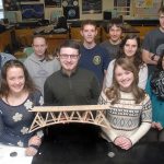 Popsicle bridge contest winners, front row from left, Bonnie Sires, Owen Nevaril and Lauren Rankin, display their winning bridge Wednesday at Port Angeles High School. Also pictured are, second row from left, second-place team Ryan Amiot, Brynn Clark and Drake Anderson, and third-place team Maya Wharton and Lael Butler. A fourth team, who entered the contest with an unofficial bridge, back row from left, Andrew Baker and Matt Lasher, were awarded with scholarship money for their bridge after it took the third-highest load during the contest. (Keith Thorpe/Peninsula Daily News)