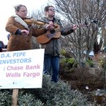 Emily Madden and Jarrod Bramson of the band Solvents play music at a protest against the Dakota Access Pipeline outside of the Port Townsend Wells Fargo on Saturday. (Cydney McFarland/Peninsula Daily News)
