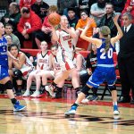 Steve Mullensky/for Peninsula Daily News Port Townsend&rsquo;s Kaitlyn Meek looks to pass past Cascade Christian defenders as Redhawks&rsquo; head coach Scott Wilson looks on. Meek scored 18 points in the second half to rally the Redhawks from a huge deficit.