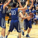 Lonnie Archibald/for Peninsula Daily News                                Forks&rsquo; Parker Browning is fouled as he drives the lane against La Center&rsquo;s Joe Bork (10) and Jake Wise (5).