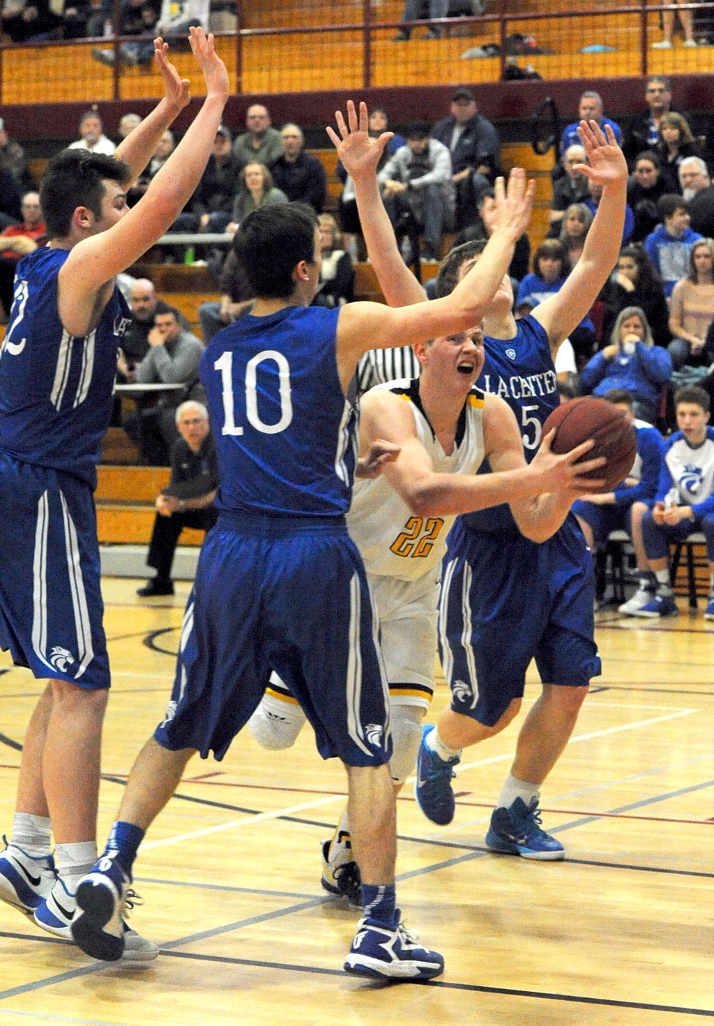Lonnie Archibald/for Peninsula Daily News Forks&rsquo; Parker Browning is fouled as he drives the lane against La Center&rsquo;s Joe Bork (10) and Jake Wise (5).