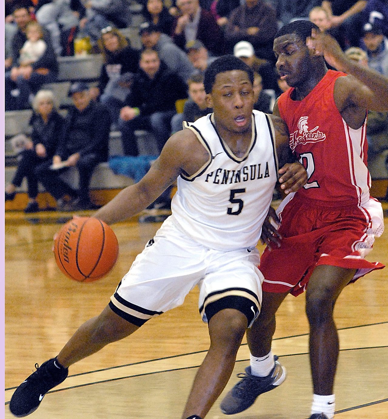 Keith Thorpe/Peninsula Daily News Peninsula&rsquo;s Darrion Daniels, left, sweeps around Everett&rsquo;s Gio Jackson in first half play on Saturday night in Port Angeles.
