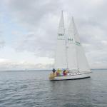 The winning boat, Sir Isaac, crosses the finish line in the middle of Port Townsend Bay on Saturday. Sir Isaac was the only boat to finish in under an hour and held a wide lead through the entire race after crossing the starting line first. (Cydney McFarland/Peninsula Daily News)