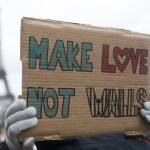 A woman holds a banner reading &ldquo;Make love not walls&rdquo; during a gathering Saturday at Trocadero Plaza next to the Eiffel Tower in Paris to protest U.S. President Donald Trump&rsquo;s recent travel ban to the U.S. (Kamil Zihnioglu/The Associated Press)