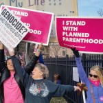 A Planned Parenthood supporter and opponent try to block each other&rsquo;s signs during a protest and counter-protest Saturday in St. Louis. Rallies aimed at urging Congress and President Donald Trump to end federal funding for Planned Parenthood were scheduled across the country. (Jim Salter/The Associated Press)