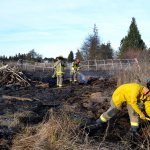 Clallam County Fire District No. 3 firefighters mop up a brush fire west of Sequim on Thursday. (Matthew Nash/Olympic Peninsula News Group)