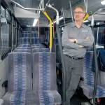 Clallam Transit operations manager Steve Hopkins stands in the aisle of a bus similar to the rolling stock being considered for a twice-daily run from Port Angeles and Sequim to Bainbridge Island. (Keith Thorpe/Peninsula Daily News)