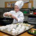 Nine-year-old Zoe Leffers, a fourth-grade student at Hamilton School in Port Angeles, creates a healthy salad Friday in the Port Angeles School District kitchen as part of the 2017 Sodexo Future Chefs Challenge. The event, part of a national initiative to promote healthy eating, brought together student teams from five Port Angeles elementary schools in a competition to cook up culinary creations with the theme of &ldquo;Healthy Comfort Foods.&rdquo; (Keith Thorpe/Peninsula Daily News)