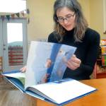 Bonnie Schmidt of Port Angeles leafs through &ldquo;Wherever You Are, My Love Will Find You&rdquo; by Nancy Tillman, a book that helped inspire Schmidt&rsquo;s &ldquo;Love Sparkle the World&rdquo; project to promote world change through reading. (Keith Thorpe/Peninsula Daily News)