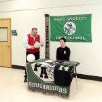 Pierre LaBossiere/Peninsula Daily News Port Angeles student-athlete Jesse Salgado prepares to sign paperwork from Port Angeles Athletic Director Dwayne Johnson to play soccer for the Peninsula College Pirates.
