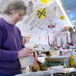 Virginia Crandall prices items for Saturday&rsquo;s community garage sale and flea market, which raises money for the Jefferson County Fairgrounds. (Cydney McFarland/Peninsula Daily News)