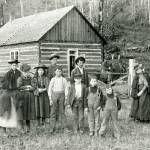 A group of unidentified adults and children stand in front of a log building in the Brinnon area in the 1890s. (Jefferson County Historial Society)