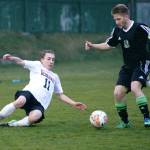 Steve Mullensky/for Peninsula Daily News Port Townsend&rsquo;s Owen Scanlon, 11, slides to block a kick attempt by Klahowya&rsquo;s Kyle Dayton during the Redhawks&rsquo; 4-1 loss to the Eagles on Friday at Memorial Field in Port Townsend.