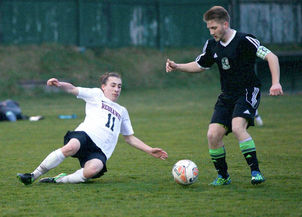 Steve Mullensky/for Peninsula Daily News Port Townsend&rsquo;s Owen Scanlon, 11, slides to block a kick attempt by Klahowya&rsquo;s Kyle Dayton during the Redhawks&rsquo; 4-1 loss to the Eagles on Friday at Memorial Field in Port Townsend.